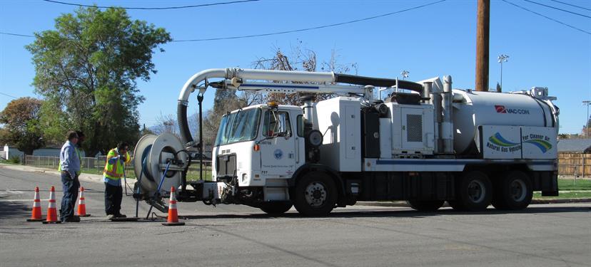 Men and water truck working in drainage sewer