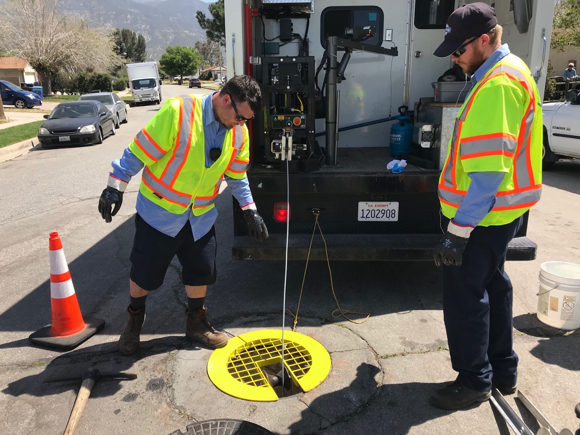 Two workers working with a drainage sewer