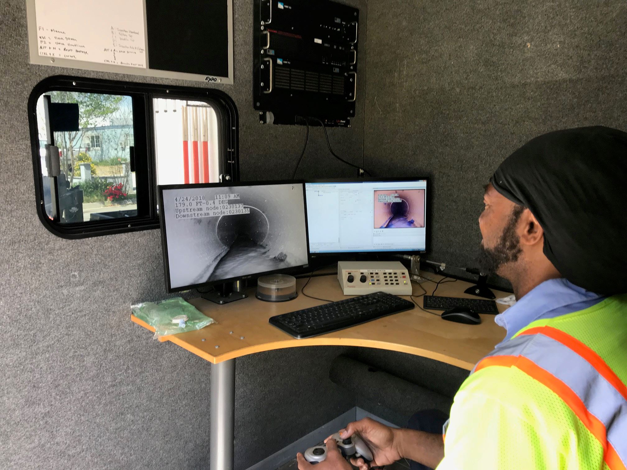 Worker sitting at computer looking at drainage sewer through the computer
