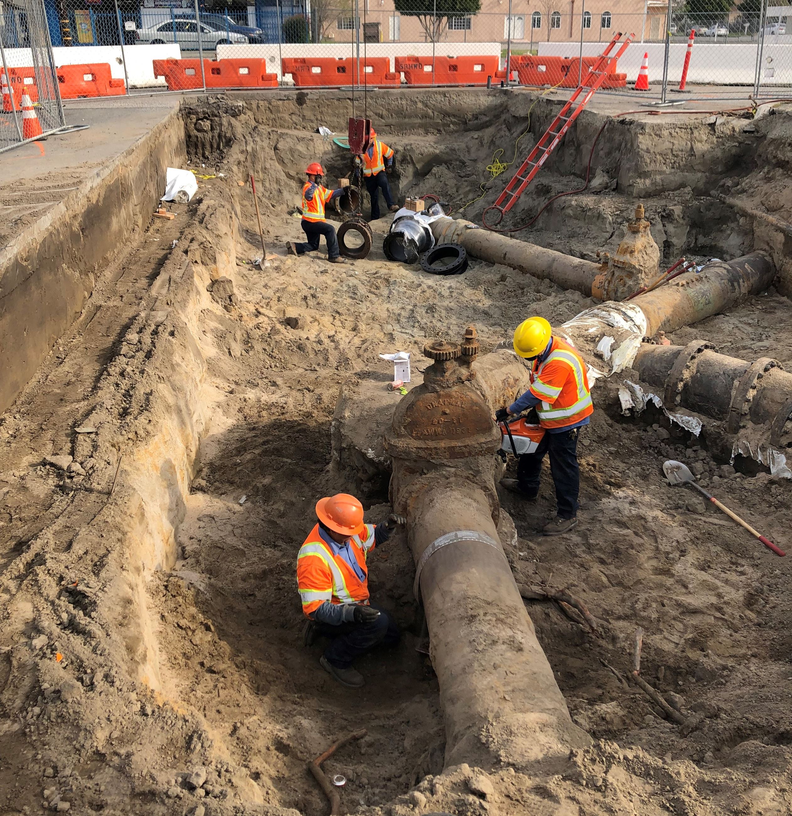 Construction workers working on pipes